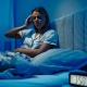 slika prikazuje žensku osobu koja pati od nesanice a na satu je otkucalo 03:58 sati ujutro. PoremeÄaj spavanja je Äest problem neovisno o dobi pacijenata.